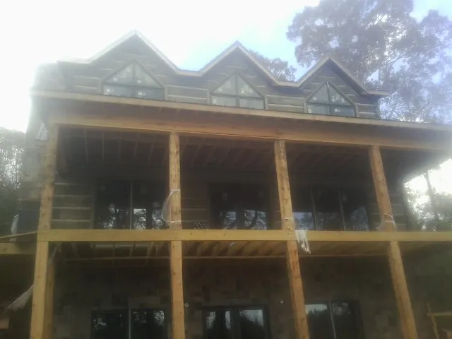 Dormers and porch framing on a large log home under construction — Roof Coating work by our crew in Shelton